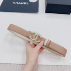 Beige belt laid flat, featuring an ornate gold-tone buckle with jeweled trim.