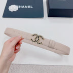 Chanel belt light beige, hand-held view, gold buckle with black stone center.