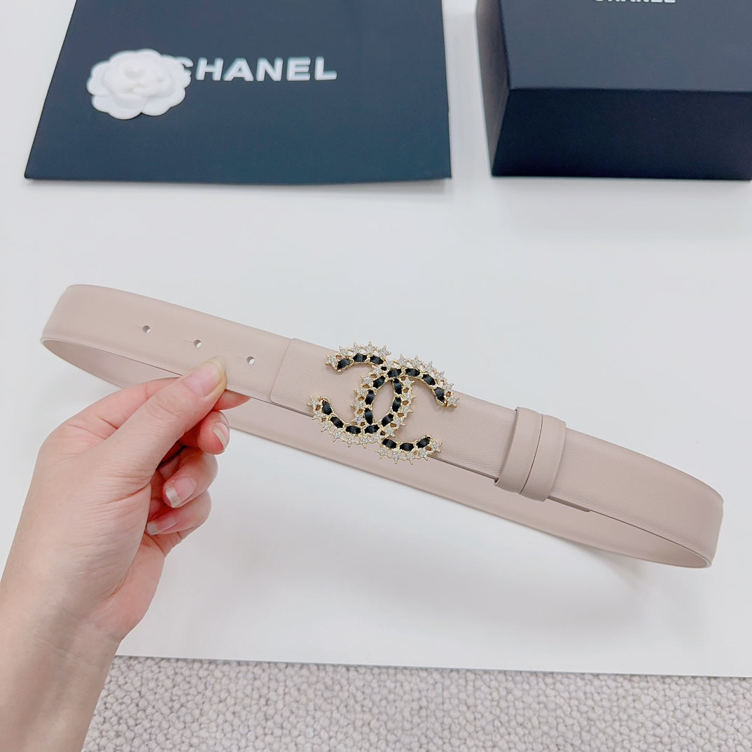 Chanel belt light beige, hand-held view, gold buckle with black stone center.