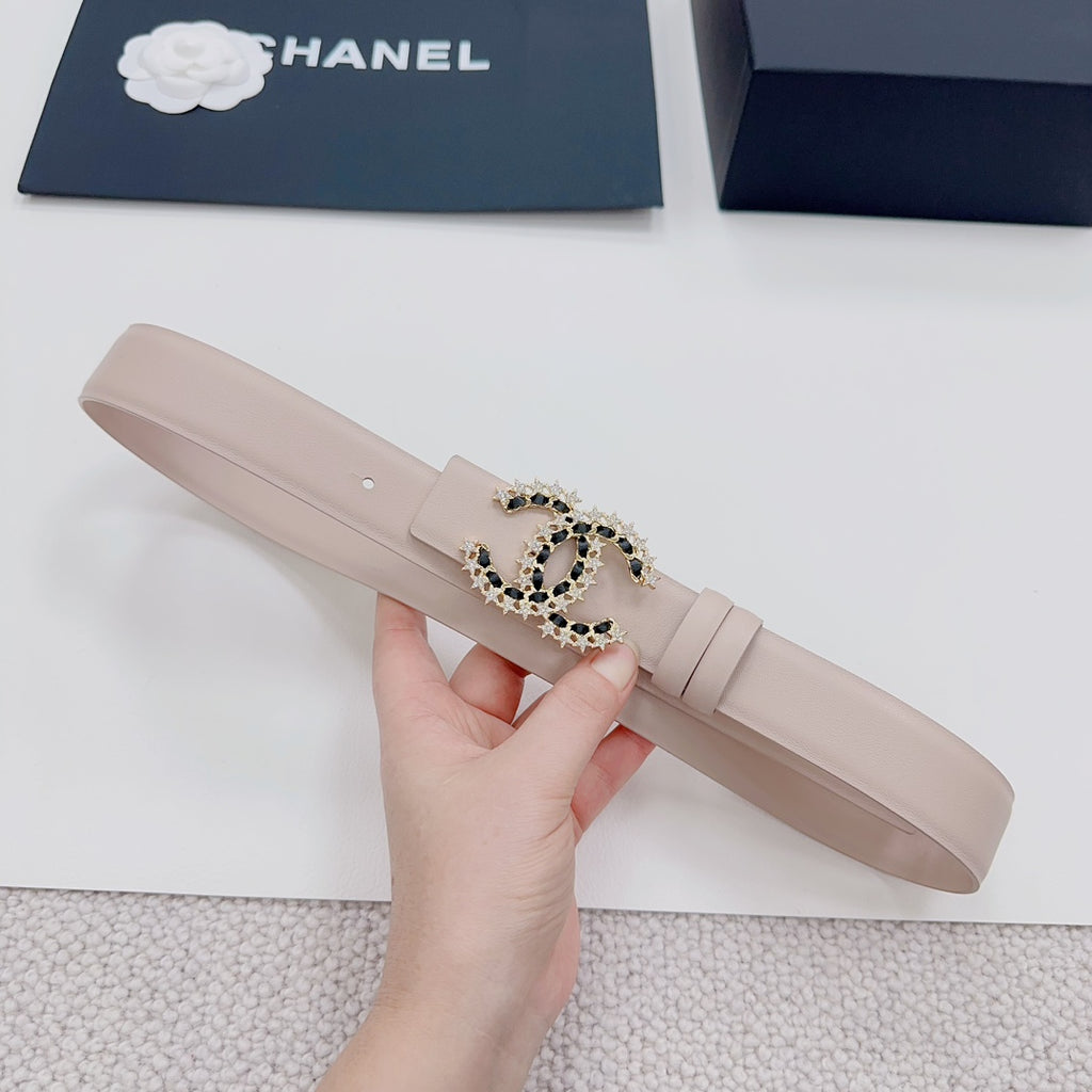 Chanel belt light beige, front view with gold buckle and black stone emblem.