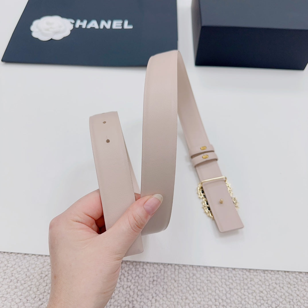 Chanel belt light beige with buckle, held upright in a hand.