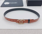 Orange and dark leather belt with ornate floral buckle centerpiece laid flat