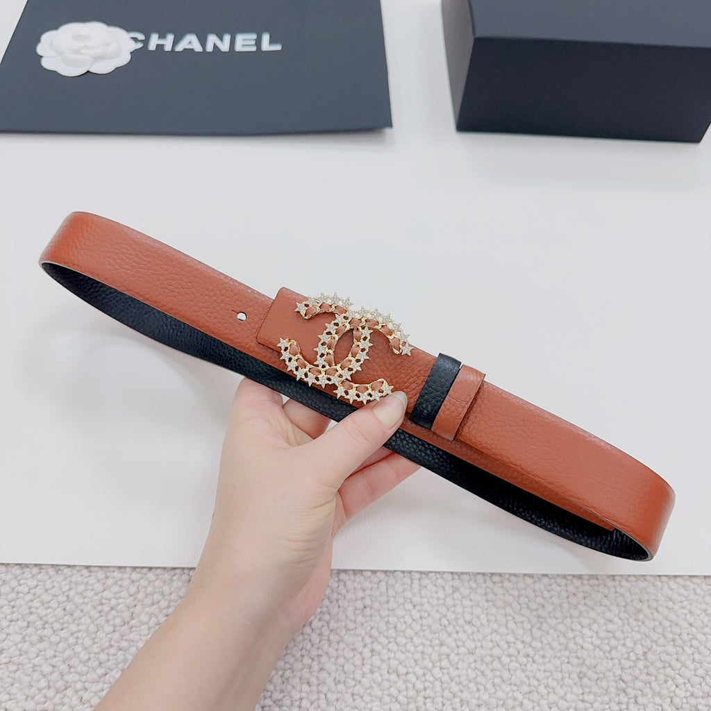 Orange leather belt with decorative floral buckle and dark trim, held horizontally