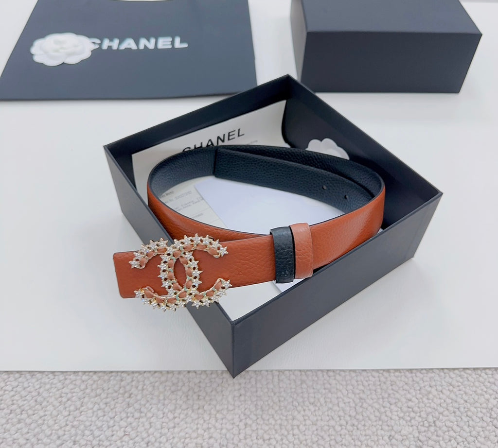 Orange leather belt with dark buckle and ornate floral metal centerpiece detail