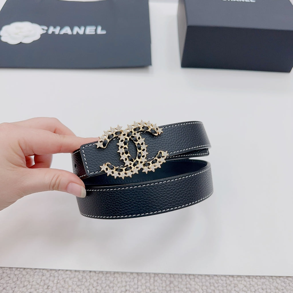Navy leather belt with gold-tone logo buckle, held up for close-up view