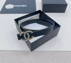 Navy leather belt with gold-tone logo buckle detail and decorative stud edges