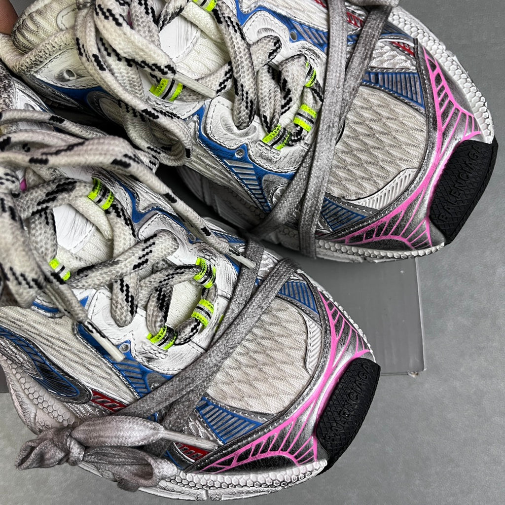 Unisex sneakers close-up, white mesh uppers with blue accents, pink trim, neon green lace tips