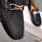 Close-up of black Versace leather loafer with gold-tone buckle and embossed medallion