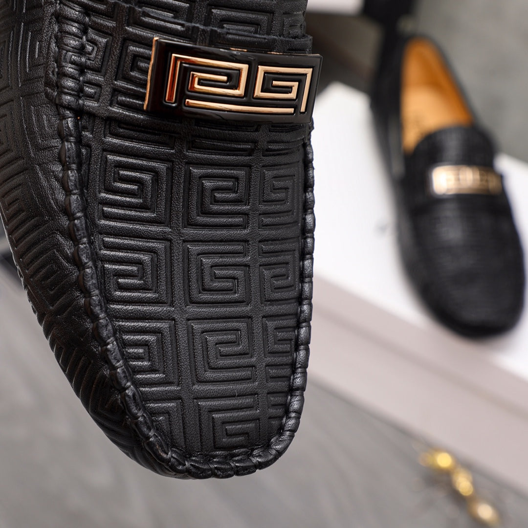 Versace luxury shoes, close-up black loafer with embossed pattern and gold accent buckle