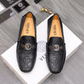 Black patterned leather loafers with gold buckle medallion and logo strap detail