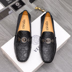 Black patterned leather loafers with gold buckle medallion and logo strap detail
