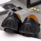 Back view of black leather loafers with textured pattern and heel tab detail