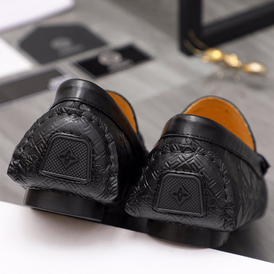 Back view of black leather loafers with textured pattern and heel tab detail