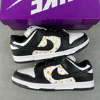 Black and white low-top sneakers with gold star paneling and black rubber sole