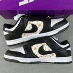 Black and white low-top sneakers with gold star print Swoosh and padded collar