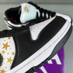 Black leather low-top sneaker with white collar and gold star logo panel