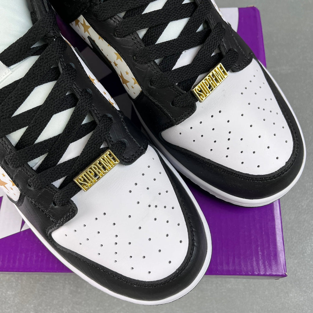 Black and white low-top sneakers with braided laces and Supreme tongue label