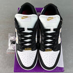Black and white low-top sneakers with white heel tabs and gold heel accents