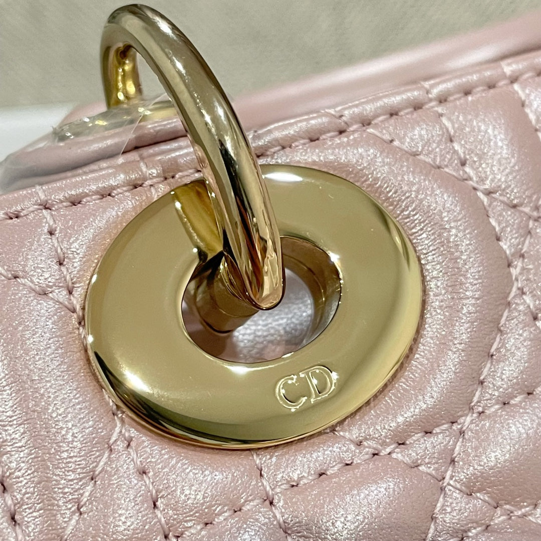 Pale pink quilted handbag with round gold hardware and CD logo detail