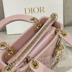 Pale pink quilted handbag interior view with gold-tone chain strap and CD charm