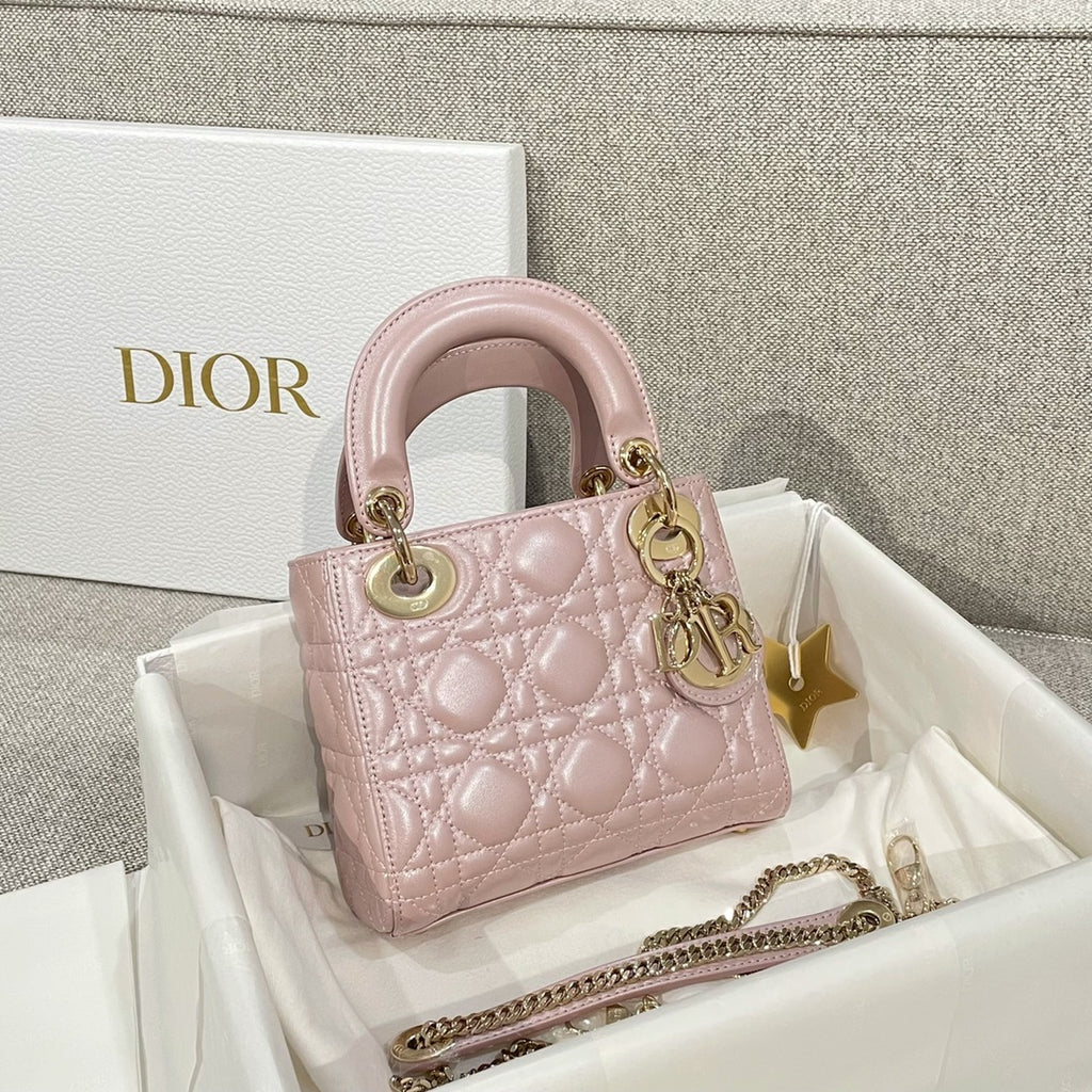 Dior mini handbag in pale pink with quilted pattern, gold-tone handles, and chain strap