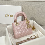 Dior mini handbag in pale pink with quilted pattern, gold-tone handles, and chain strap
