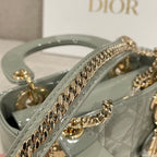 Sage green quilted patent handbag with gold chain trim on the front