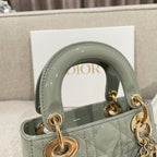 Sage green patent handbag close-up of top handle and gold ring hardware