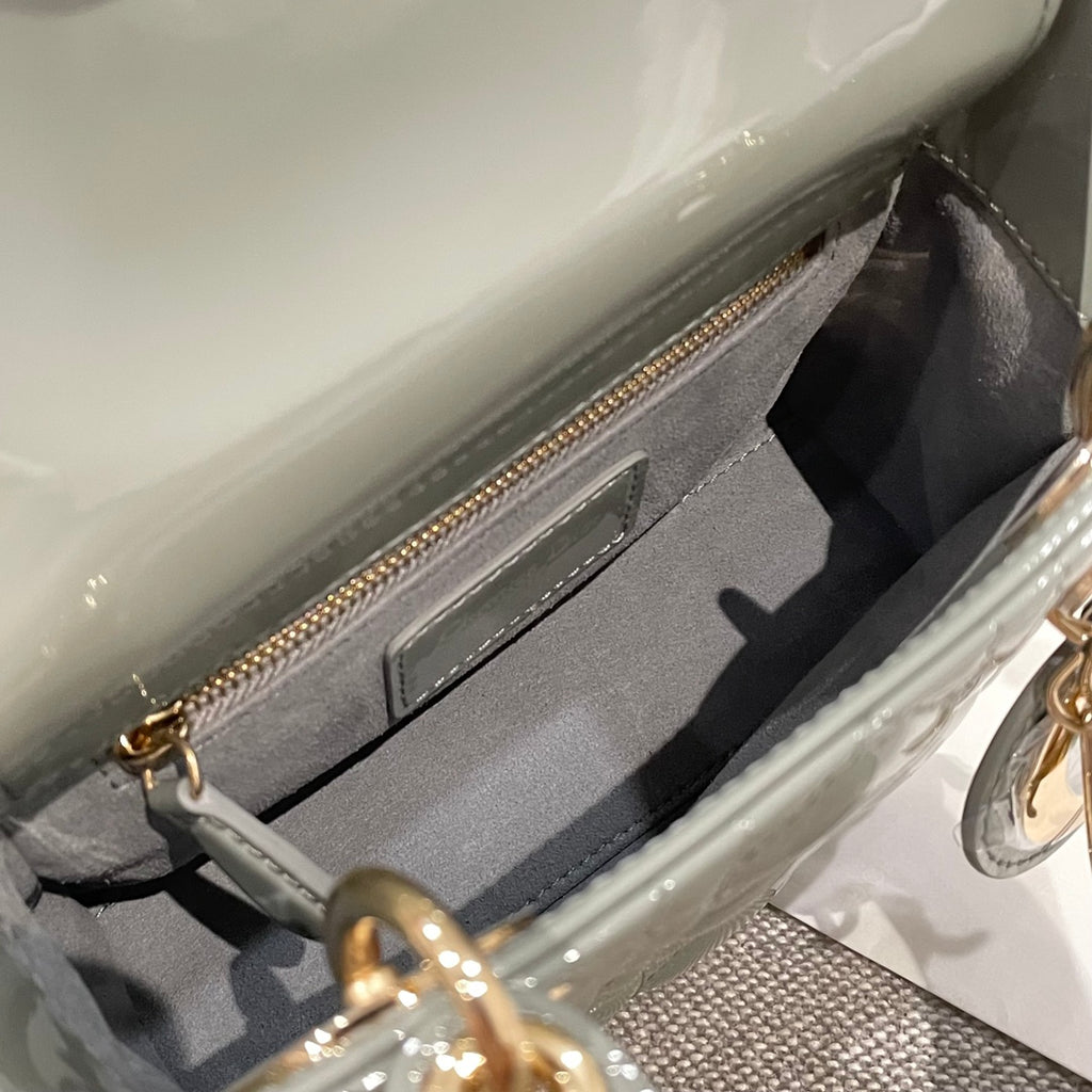 Sage green patent handbag interior pocket with zip top and gold zipper pull