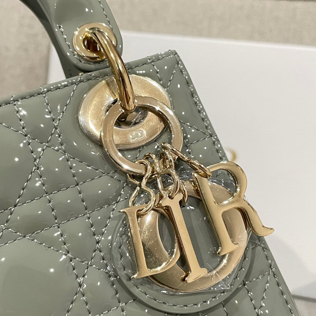 Sage green patent handbag charm detail with gold Dior initials and ring clasp