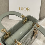 Sage green patent handbag interior view with top handles and chain strap