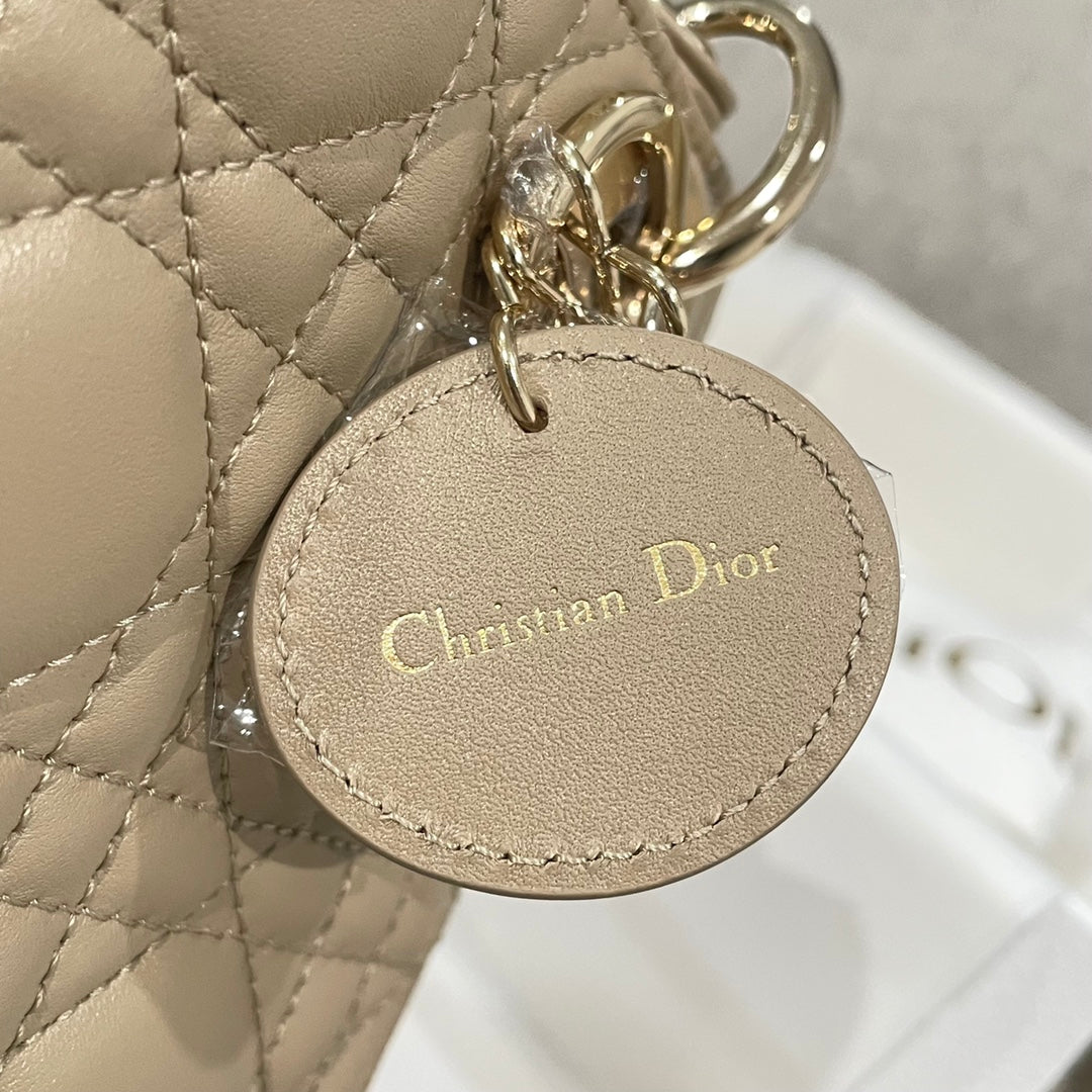 Round Christian Dior logo charm on gold-tone chain