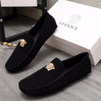 Pair of black suede loafers with gold Medusa crest and stitched side seam