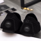 Black suede loafer heel with circular embossed medallion and rubber sole