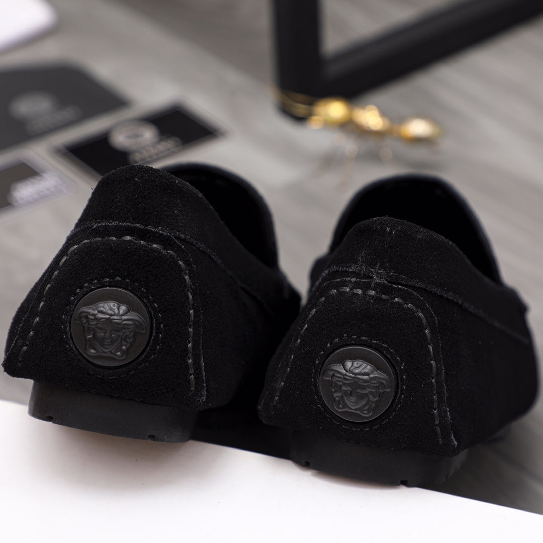 Black suede loafer heel with circular embossed medallion and rubber sole