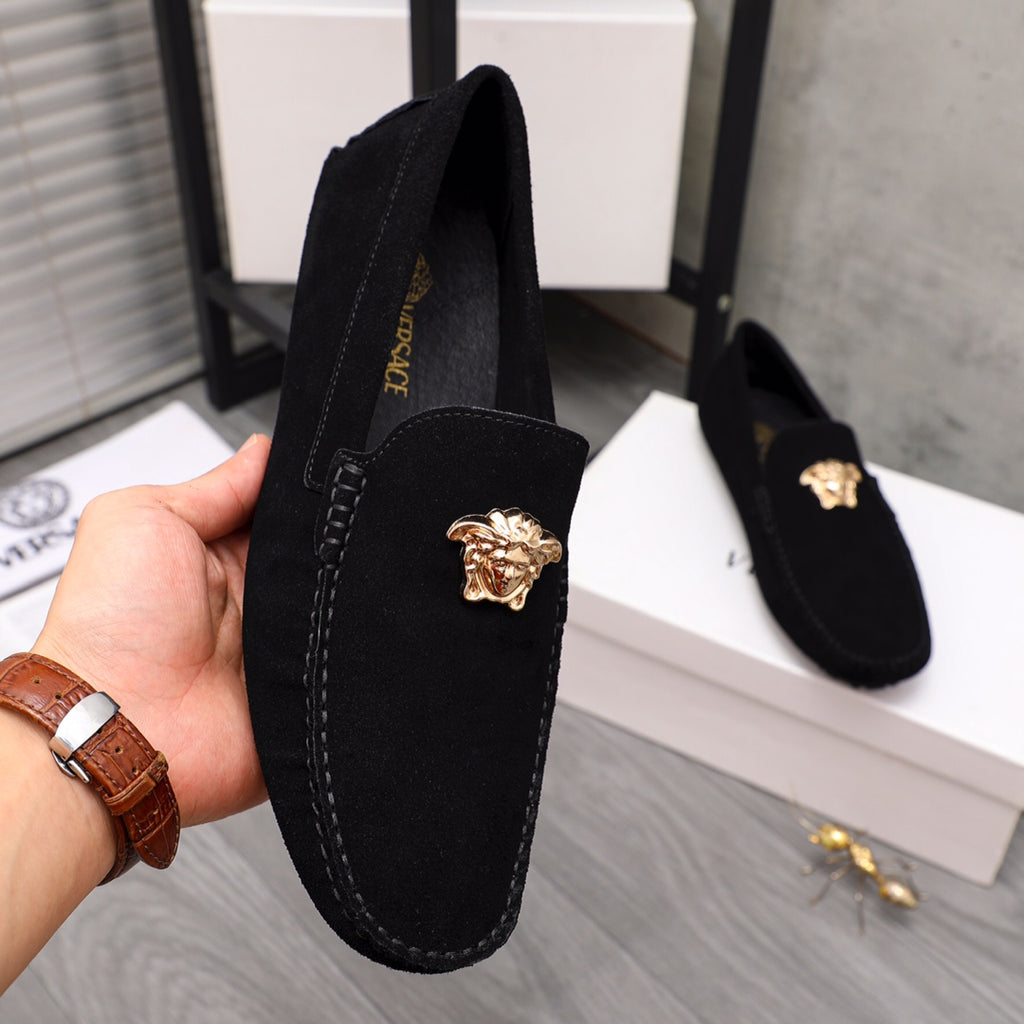 Black suede loafer with gold Medusa crest, stitched edge, and hand-held close view