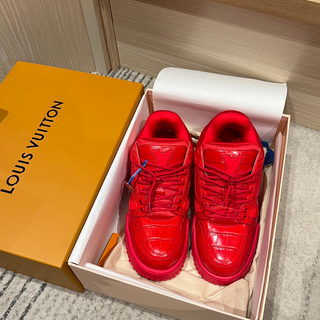 Louis Vuitton red trainer sneakers in a box with visible laces and blue sock lining