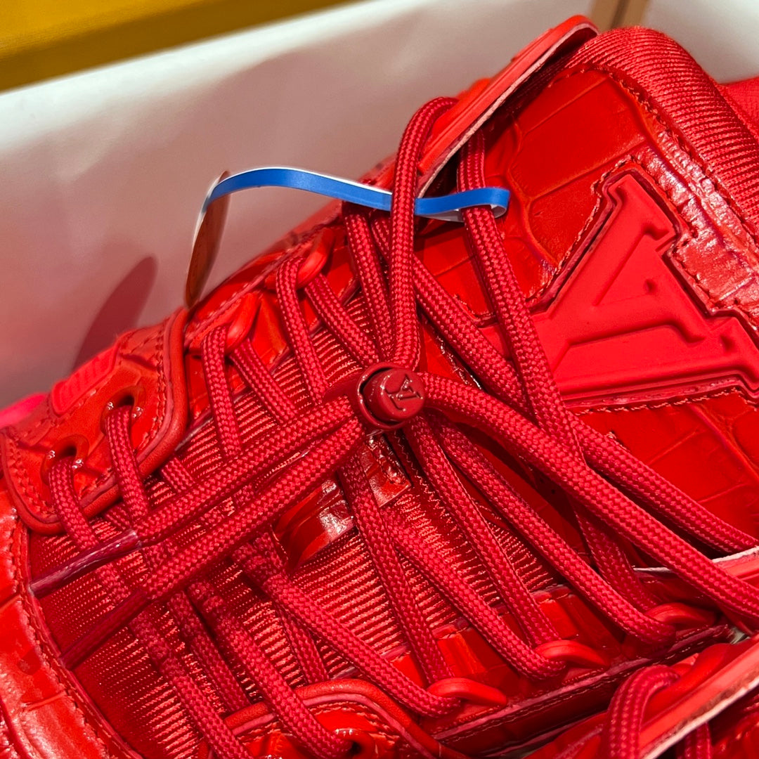 Louis Vuitton red trainer sneaker close-up with woven laces and embossed logo detailing