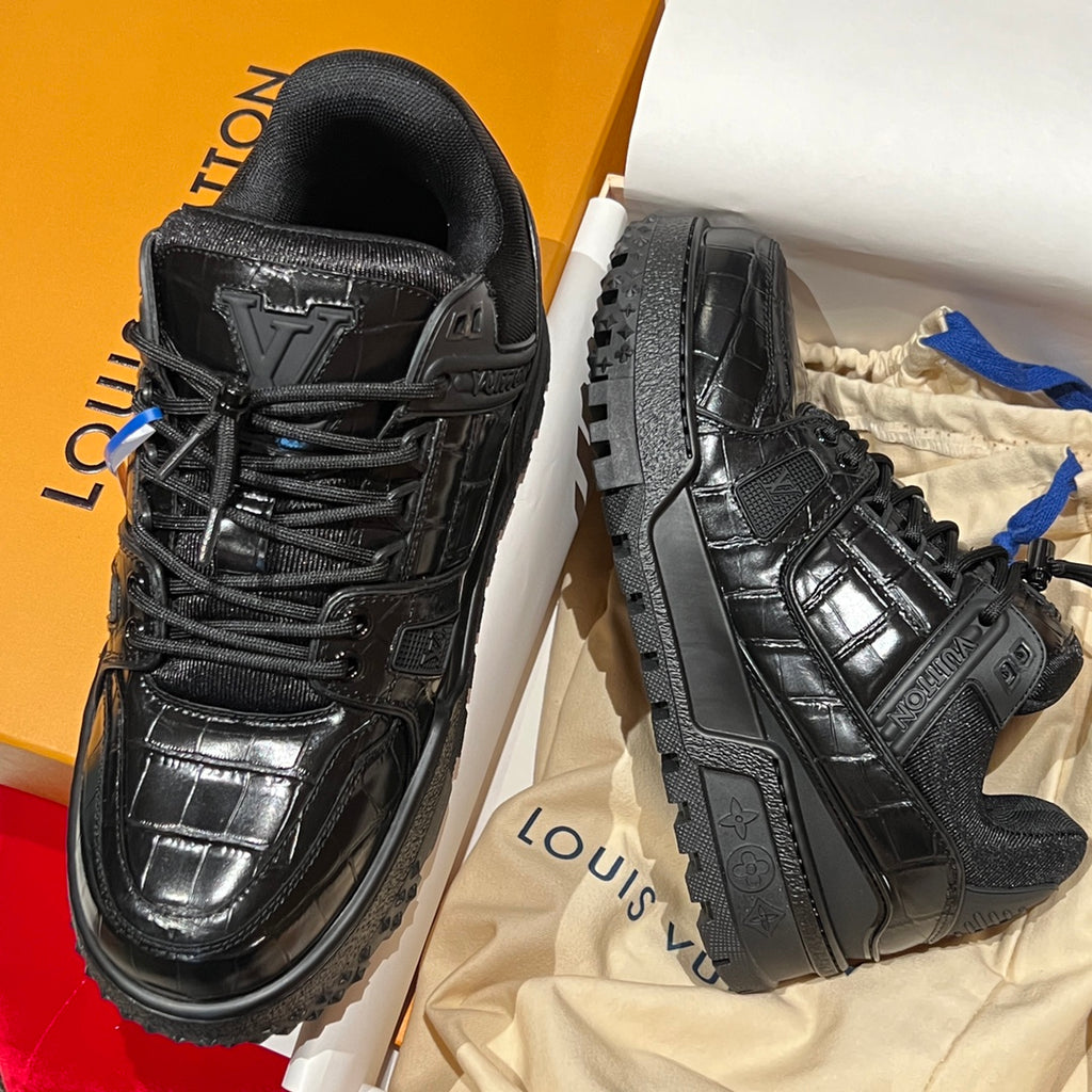 Black Louis Vuitton trainer sneakers in a box, angled side views.