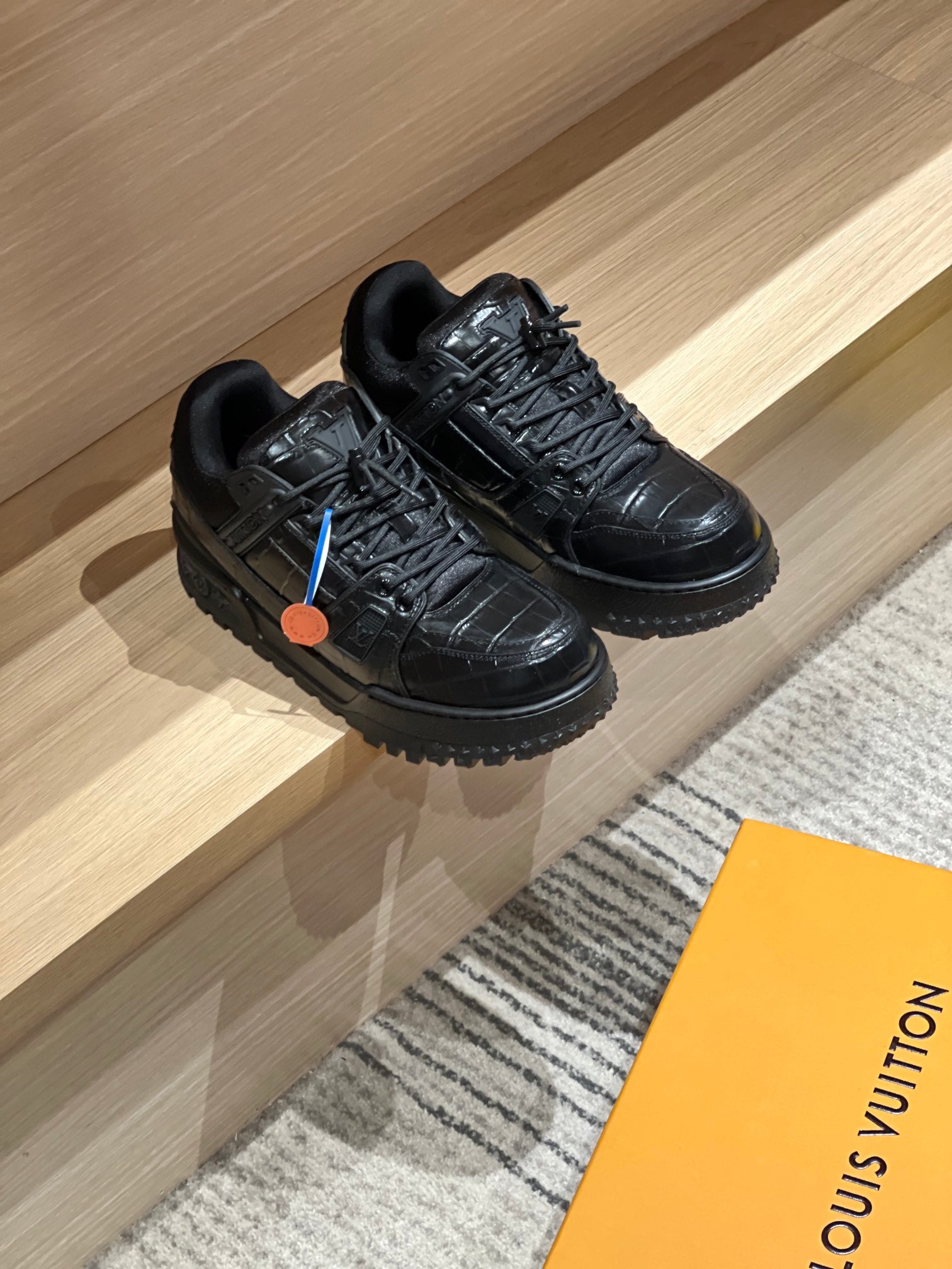 Black lace-up trainer sneakers shown as a pair with chunky tread soles.