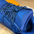 Louis Vuitton trainer shoe close-up, blue lace-up with embossed side emblem