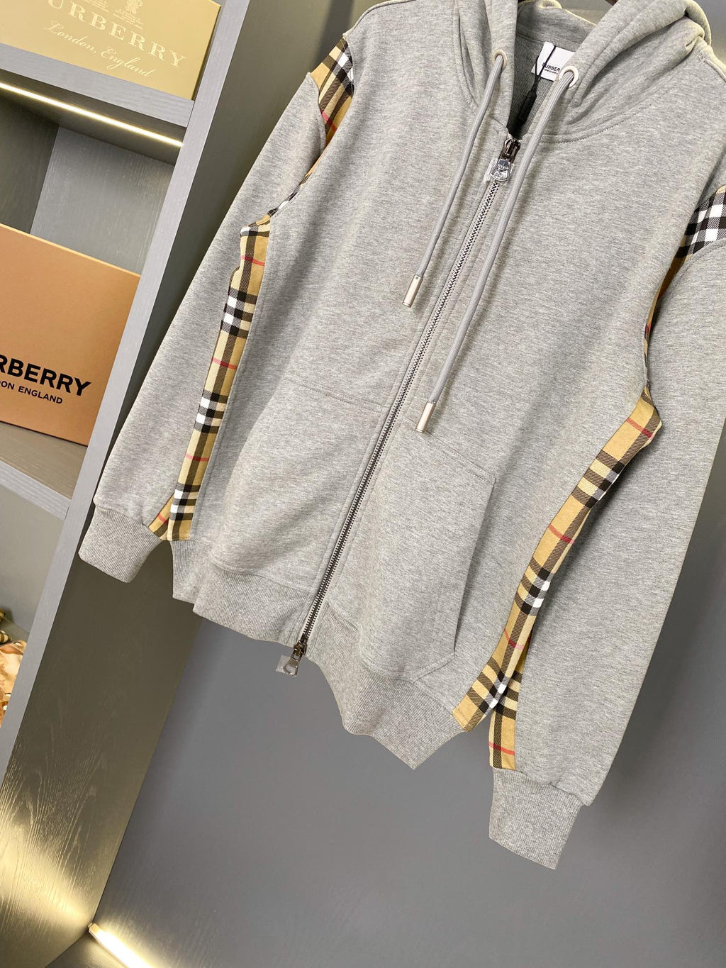 Heather gray zip-up hoodie with hood drawstrings and plaid sleeve trim