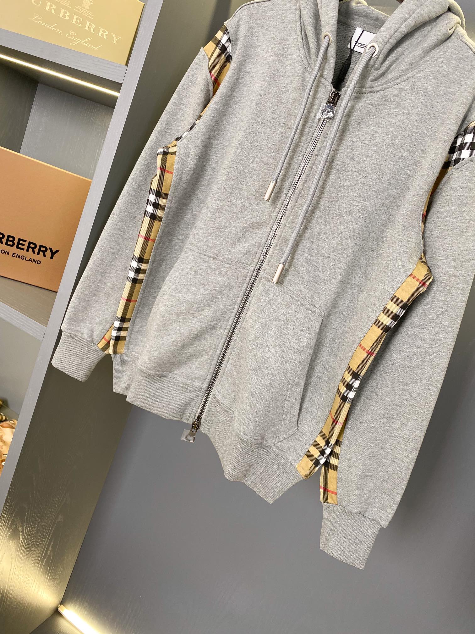 Heather gray zip-up hoodie with hood drawstrings and plaid sleeve trim