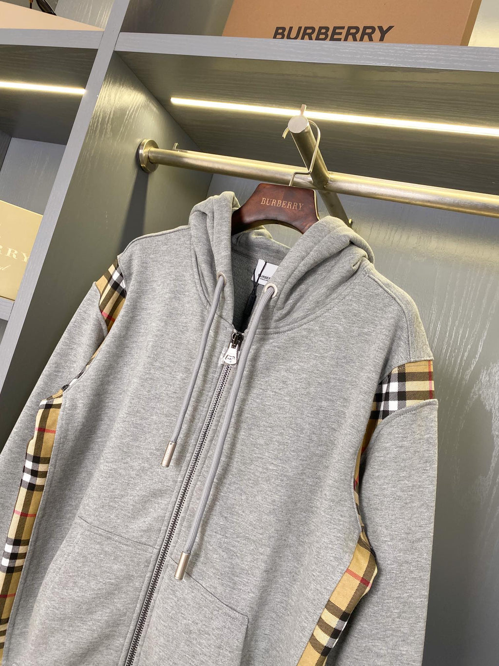 Heather gray hooded zip-up sweatshirt with plaid sleeve panels and drawstring hood