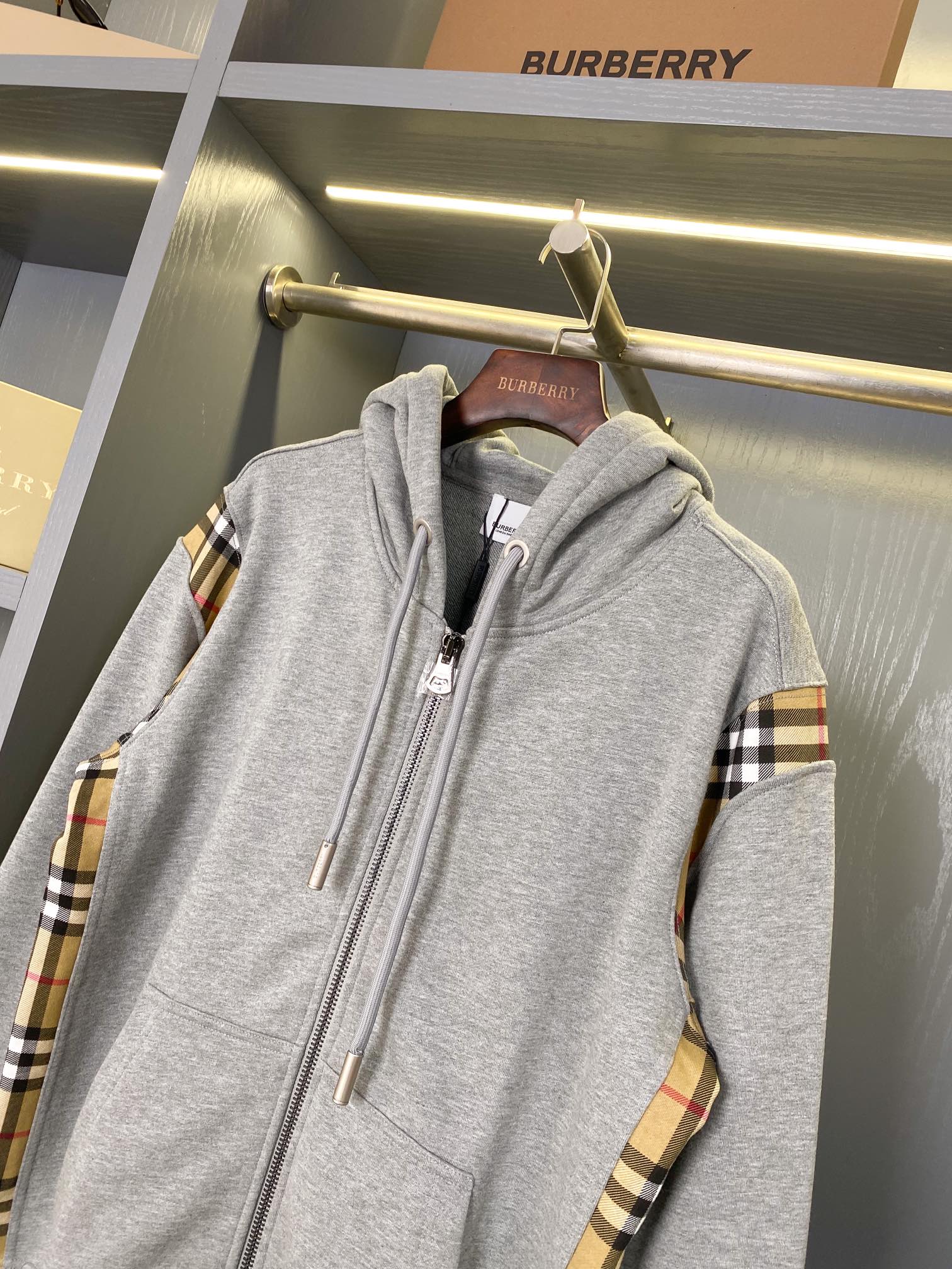 Heather gray hooded zip-up sweatshirt with plaid sleeve panels and drawstring hood