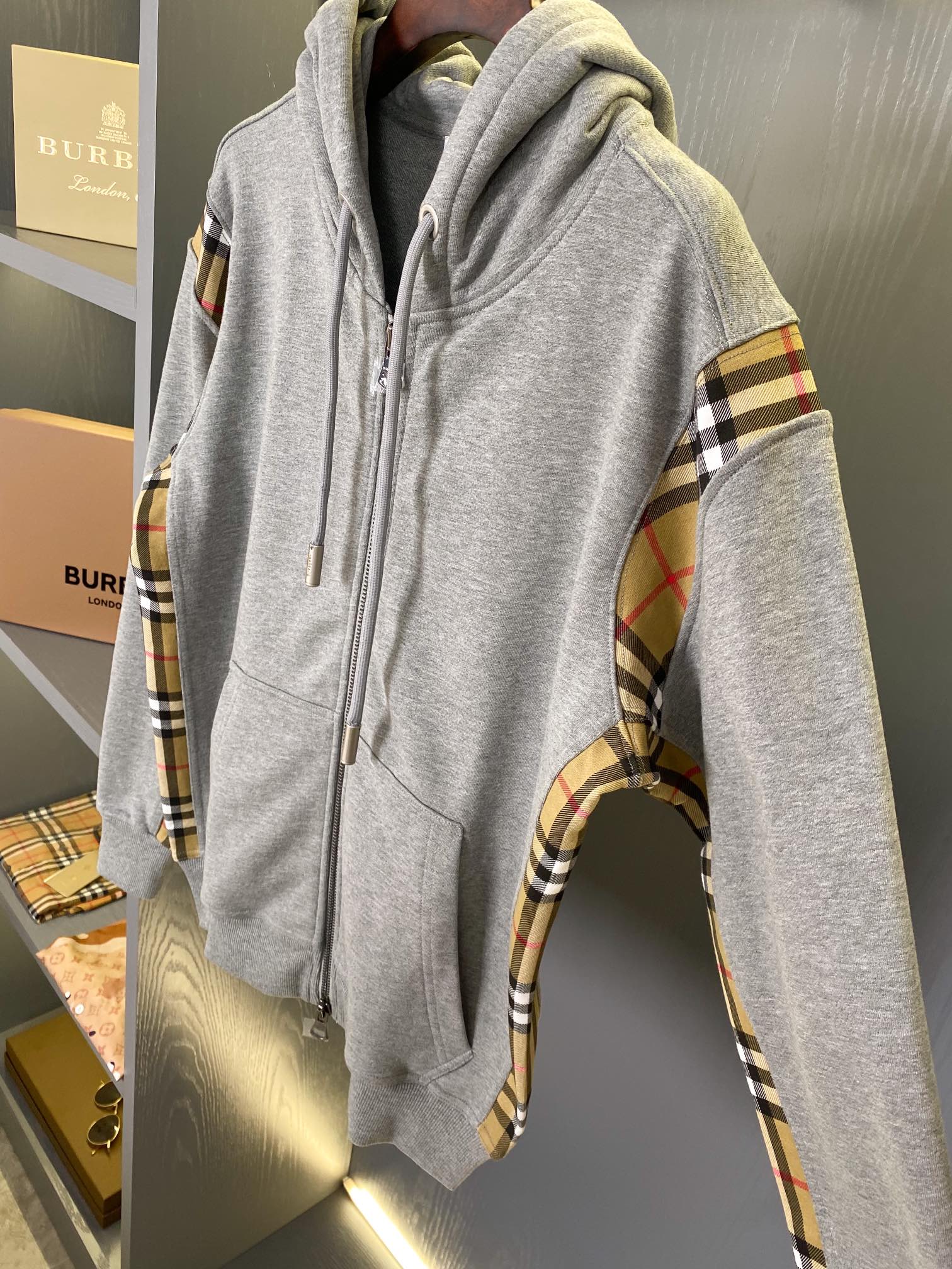 Heather gray hooded zip-up sweatshirt with plaid sleeves and adjustable drawstring hood