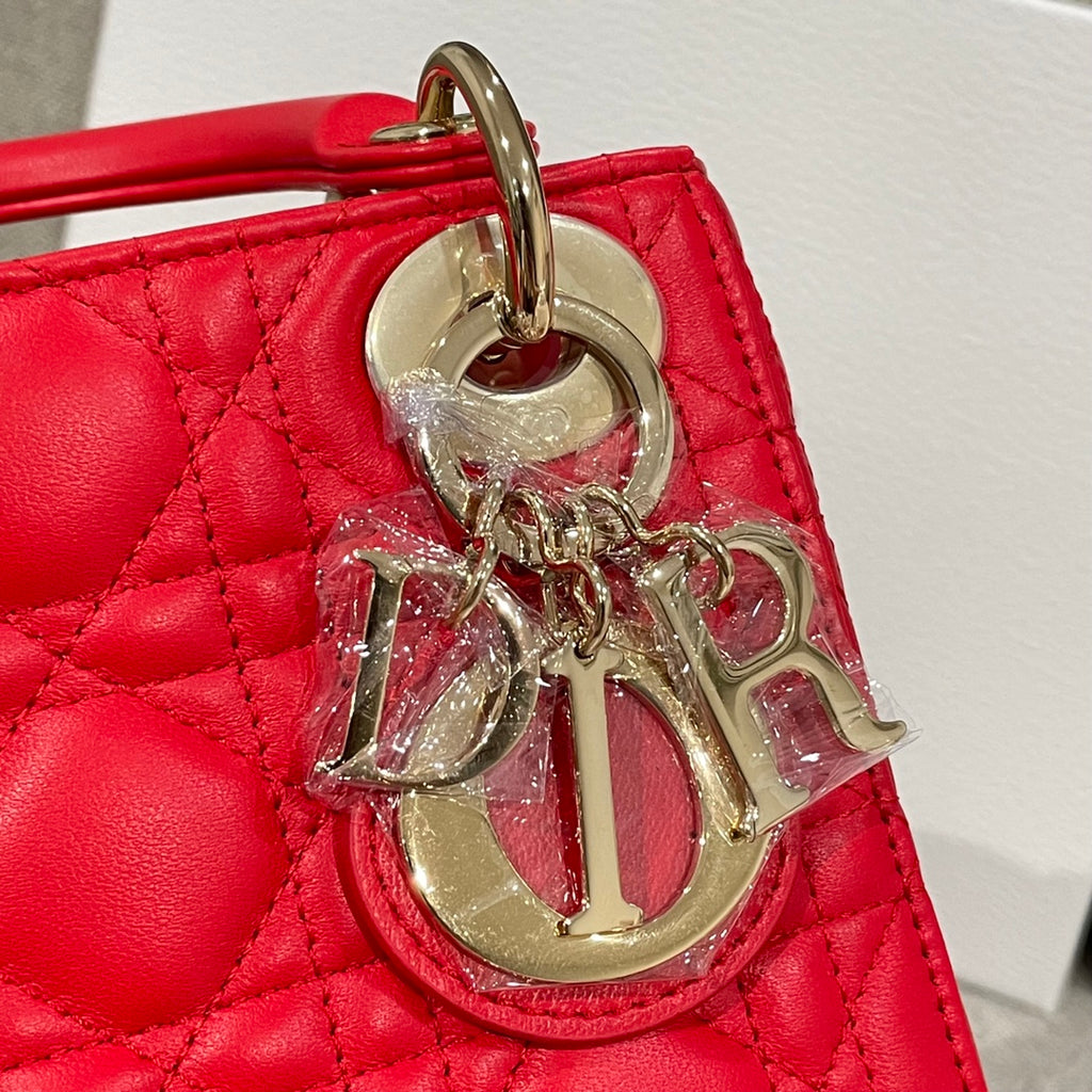 Red Dior handbag with large silver-tone “Dior” charm on the front