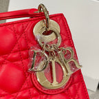 Red Dior handbag with large silver-tone “Dior” charm on the front
