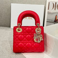 Red quilted Dior handbag with top handles and dangling charm detail