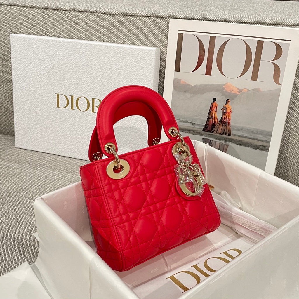 Red quilted Dior handbag with top handles, charm, and gold-tone hardware
